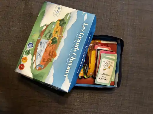 Boîte du jeu Les Grands Chevaux, la course des 4 saisons, ouverte sur ses cartes